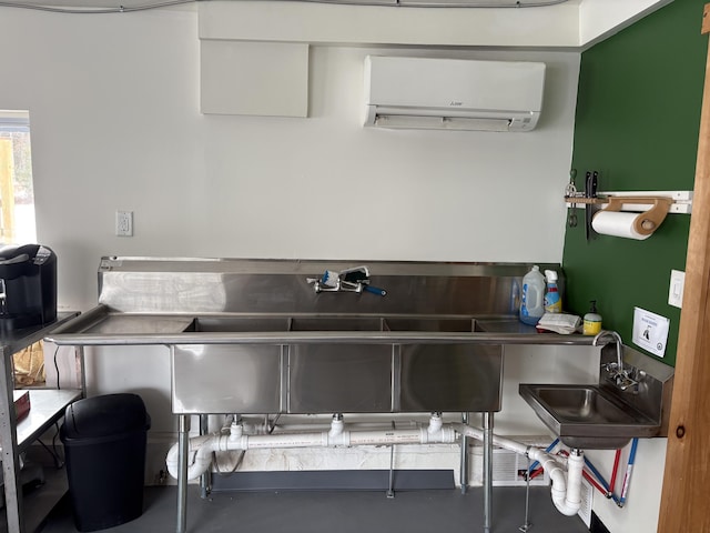 kitchen featuring sink, an AC wall unit, and white cabinets