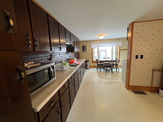 kitchen with sink, tasteful backsplash, and dark brown cabinetry