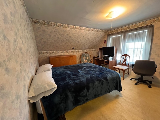 carpeted bedroom with lofted ceiling