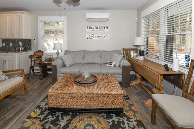 living room featuring a wall unit AC, dark wood-type flooring, and ceiling fan