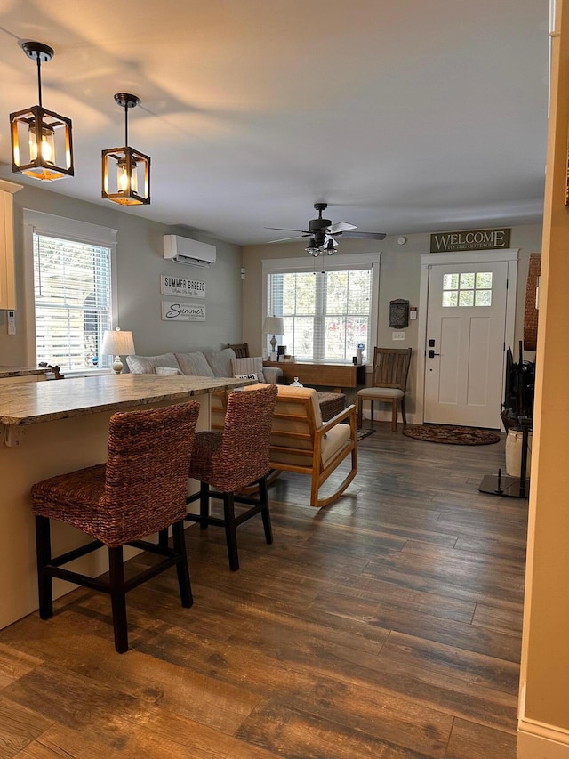 dining area with ceiling fan, an AC wall unit, dark hardwood / wood-style floors, and plenty of natural light