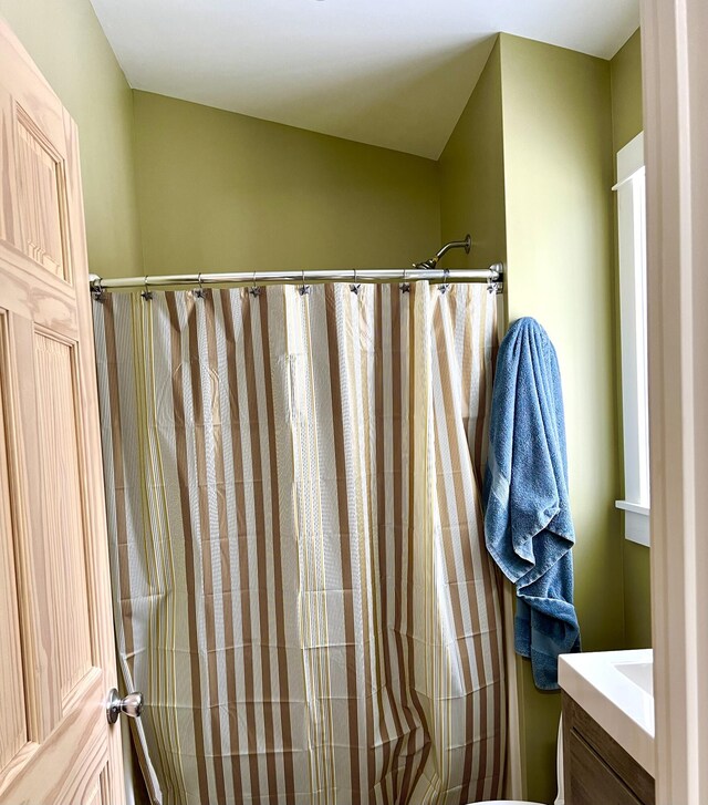 bathroom with toilet, vanity, and a shower with shower curtain