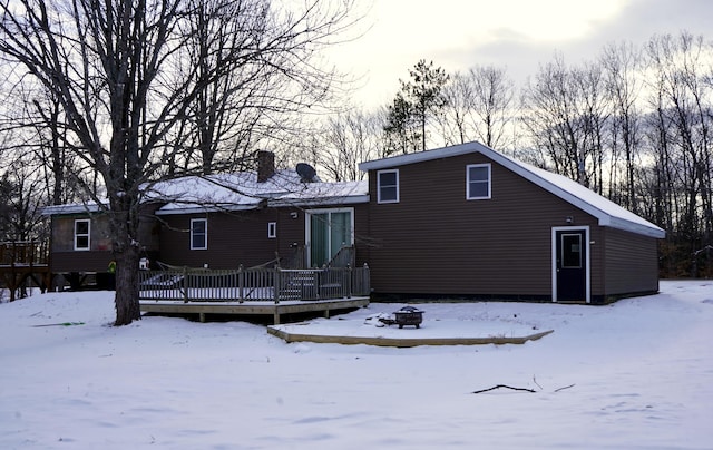 snow covered property with a deck and a fire pit