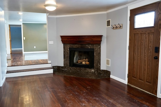 entrance foyer featuring a premium fireplace, dark hardwood / wood-style flooring, and crown molding