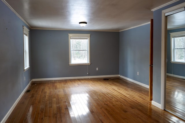 spare room featuring crown molding and hardwood / wood-style floors