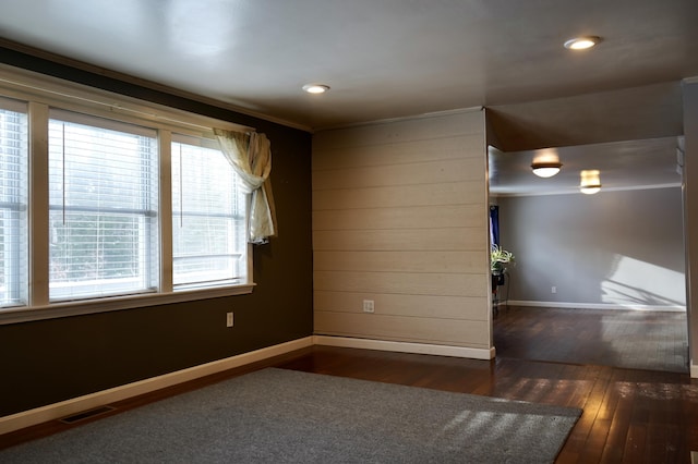 unfurnished room with dark wood-type flooring and crown molding