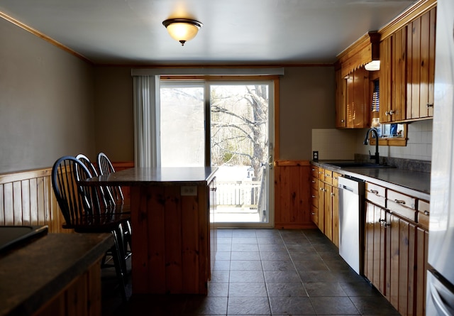 kitchen featuring decorative backsplash, dishwasher, sink, and crown molding