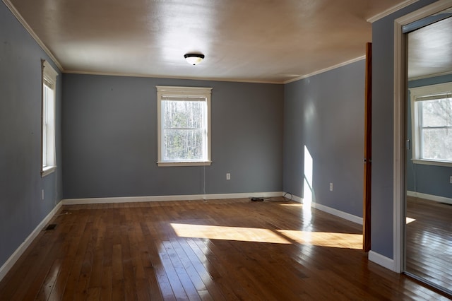 empty room featuring ornamental molding and hardwood / wood-style floors