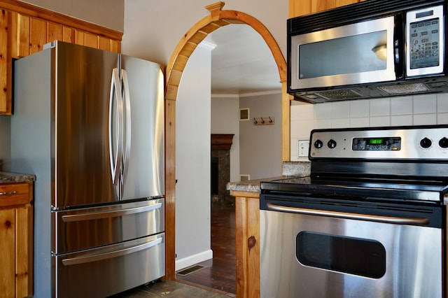 kitchen featuring backsplash, crown molding, and stainless steel appliances