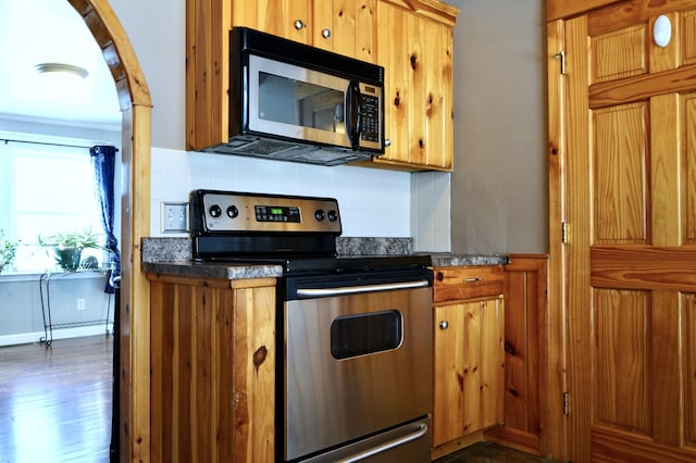 kitchen featuring backsplash, appliances with stainless steel finishes, and ornamental molding