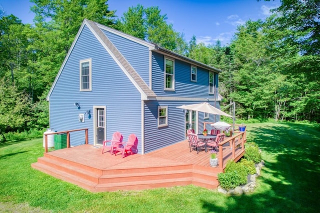 rear view of house with a deck and a yard