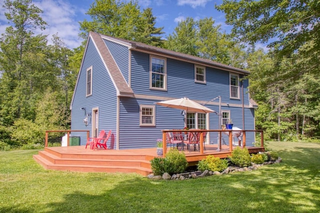 rear view of house with a lawn and a wooden deck