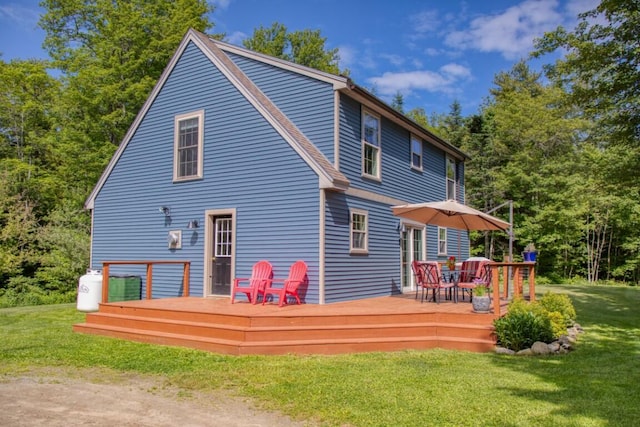 rear view of house with a deck and a lawn