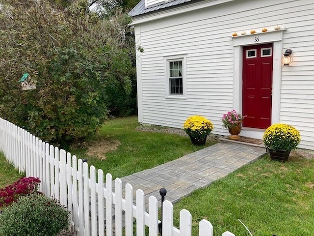 property entrance featuring a lawn