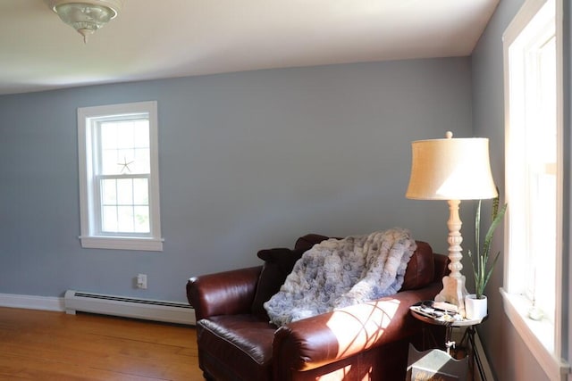 living area featuring a baseboard radiator and hardwood / wood-style flooring