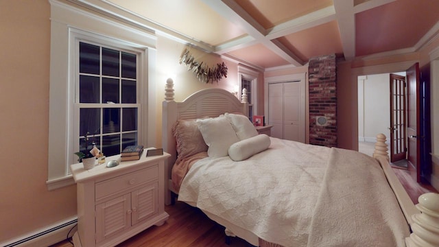 bedroom featuring beamed ceiling, coffered ceiling, a baseboard radiator, a closet, and light wood-type flooring