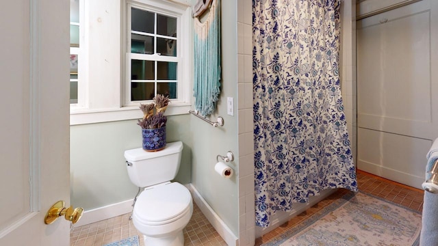 bathroom featuring toilet, walk in shower, and tile patterned flooring