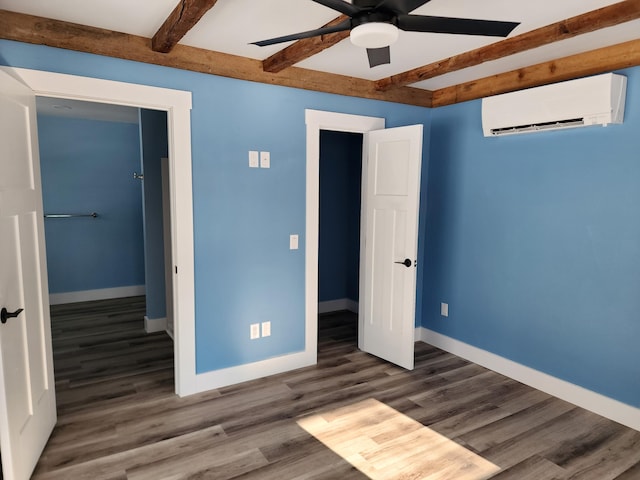 61 Hathaway Hill Rd, Livermore, ME 04253 - unfurnished bedroom with an AC wall unit, beam ceiling, wood finished floors, baseboards, and ceiling fan