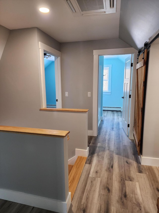 61 Hathaway Hill Rd, Livermore, ME 04253 - corridor with a baseboard radiator, wood finished floors, a barn door, recessed lighting, and baseboards