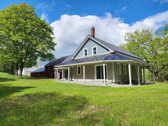 61 Hathaway Hill Rd, Livermore, ME 04253 - rear view of property with a chimney, a lawn, metal roof, a standing seam roof, and a patio
