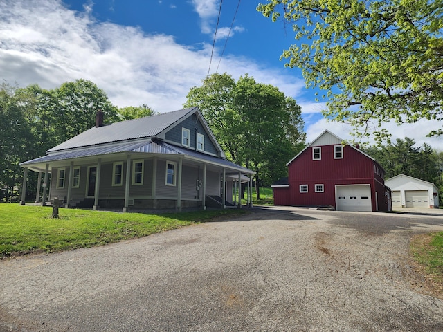 61 Hathaway Hill Rd, Livermore, ME 04253 - view of home's exterior with a detached garage, an outdoor structure, metal roof, a yard, and a chimney