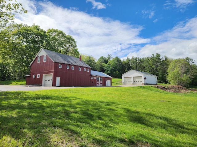 61 Hathaway Hill Rd, Livermore, ME 04253 - view of green lawn featuring a detached garage and an outbuilding