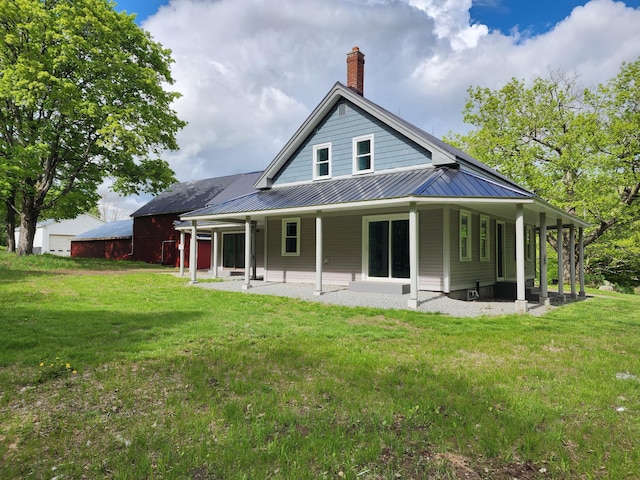 61 Hathaway Hill Rd, Livermore, ME 04253 - rear view of house featuring a chimney, a yard, metal roof, and a patio