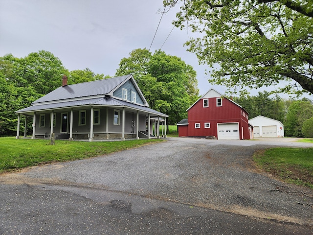 61 Hathaway Hill Rd, Livermore, ME 04253 - view of property exterior featuring a detached garage, an outdoor structure, a chimney, metal roof, and a porch