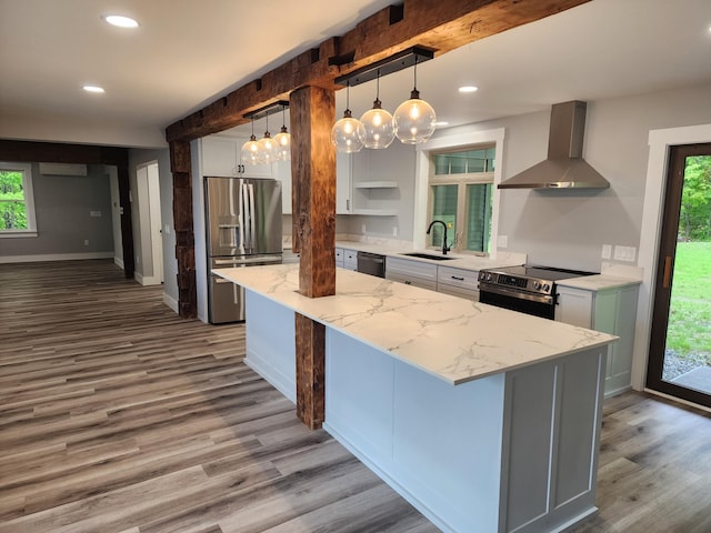 61 Hathaway Hill Rd, Livermore, ME 04253 - kitchen with wall chimney range hood, stainless steel appliances, wood finished floors, healthy amount of natural light, and recessed lighting