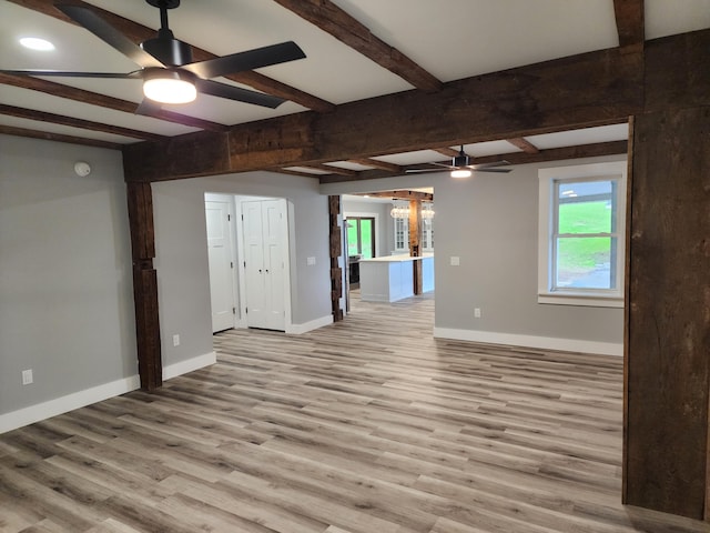 61 Hathaway Hill Rd, Livermore, ME 04253 - unfurnished living room featuring a ceiling fan, baseboards, wood finished floors, healthy amount of natural light, and beamed ceiling