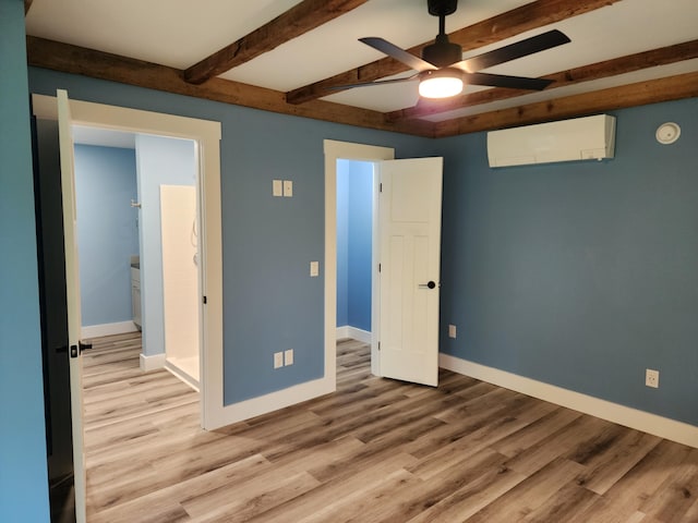 61 Hathaway Hill Rd, Livermore, ME 04253 - unfurnished bedroom featuring a wall unit AC, wood finished floors, baseboards, beamed ceiling, and ceiling fan
