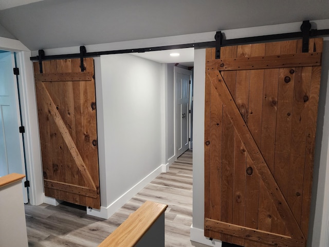 61 Hathaway Hill Rd, Livermore, ME 04253 - hallway with a barn door, baseboards, light wood finished floors, and recessed lighting