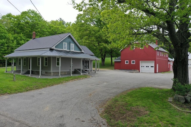 61 Hathaway Hill Rd, Livermore, ME 04253 - view of front of home featuring asphalt driveway, a garage, an outdoor structure, and a front yard
