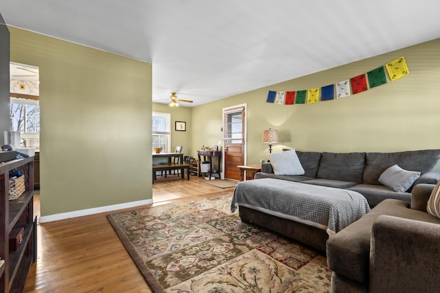 living room with ceiling fan, a wealth of natural light, and dark wood-type flooring