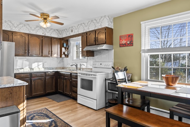 kitchen with white range with electric stovetop, ceiling fan, stainless steel fridge, dark brown cabinetry, and light hardwood / wood-style flooring