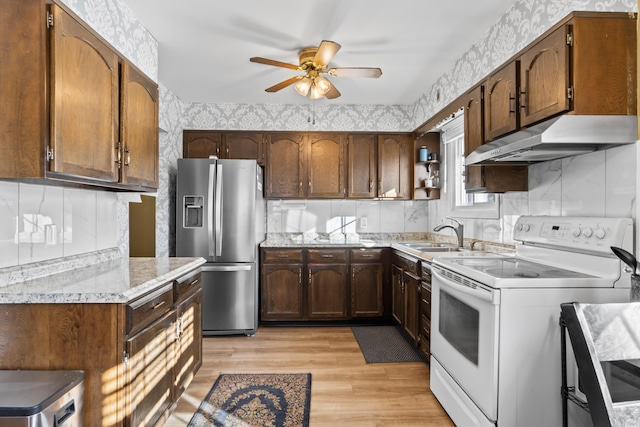 kitchen featuring sink, ceiling fan, light wood-type flooring, stainless steel refrigerator with ice dispenser, and white electric range