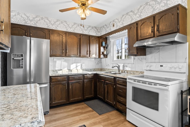 kitchen featuring sink, light wood-type flooring, ceiling fan, stainless steel fridge with ice dispenser, and white electric range