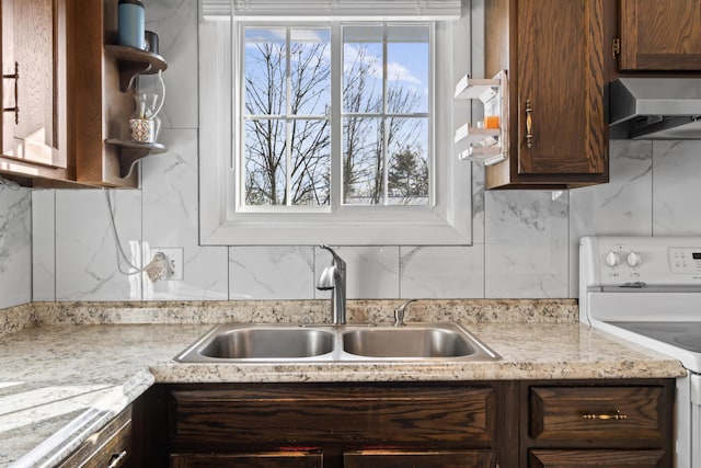 kitchen featuring wall chimney exhaust hood, sink, tasteful backsplash, white electric stove, and dark brown cabinetry