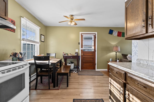 kitchen with light hardwood / wood-style flooring, decorative backsplash, baseboard heating, white electric range, and ceiling fan