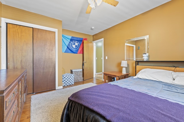 bedroom featuring ceiling fan, light hardwood / wood-style flooring, and a closet