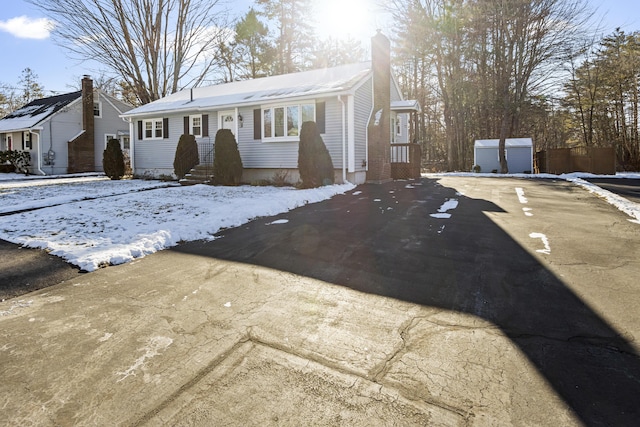 single story home featuring a shed