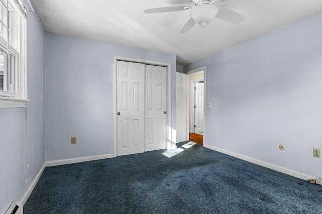 unfurnished bedroom featuring ceiling fan, carpet, a baseboard heating unit, and a closet