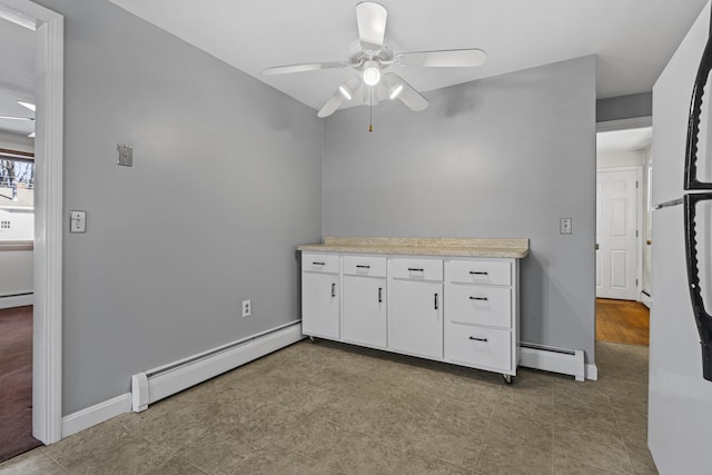 interior space with ceiling fan and a baseboard heating unit