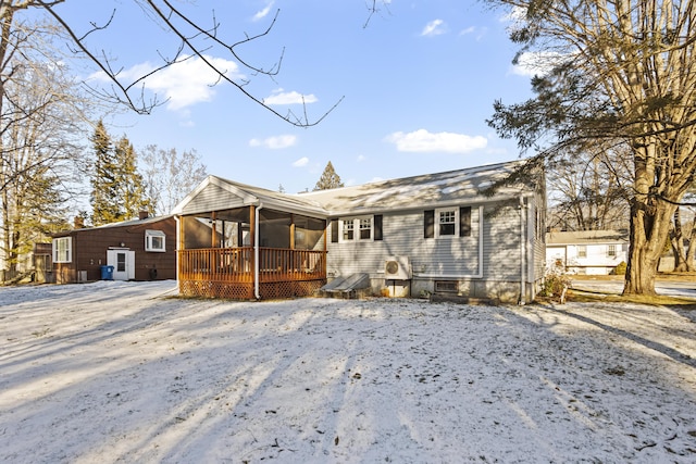 rear view of house with a wooden deck and a sunroom