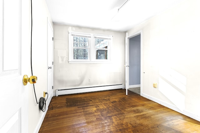 interior space with a baseboard heating unit and dark hardwood / wood-style flooring