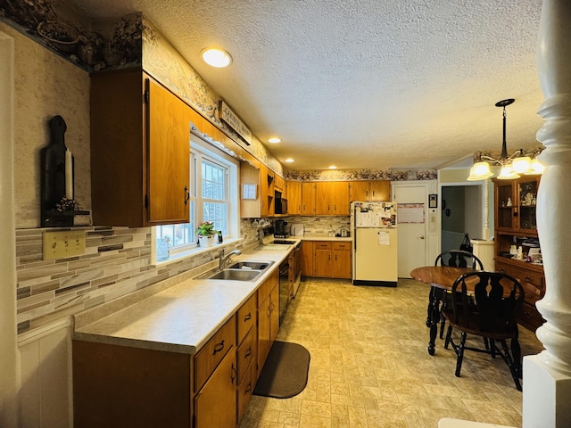 kitchen featuring white fridge, sink, hanging light fixtures, backsplash, and a notable chandelier