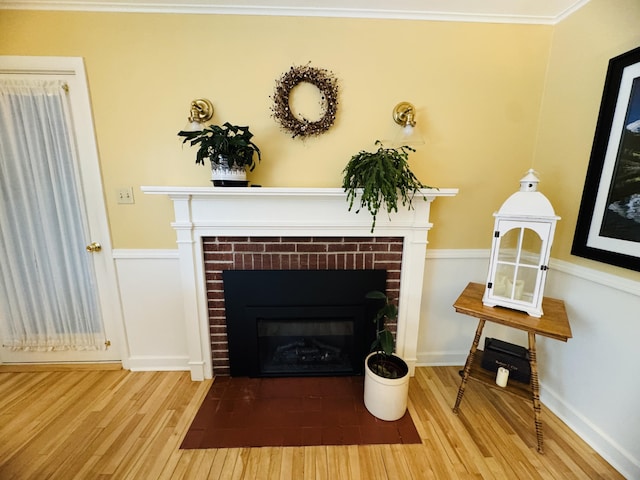 room details featuring a brick fireplace, ornamental molding, and hardwood / wood-style floors