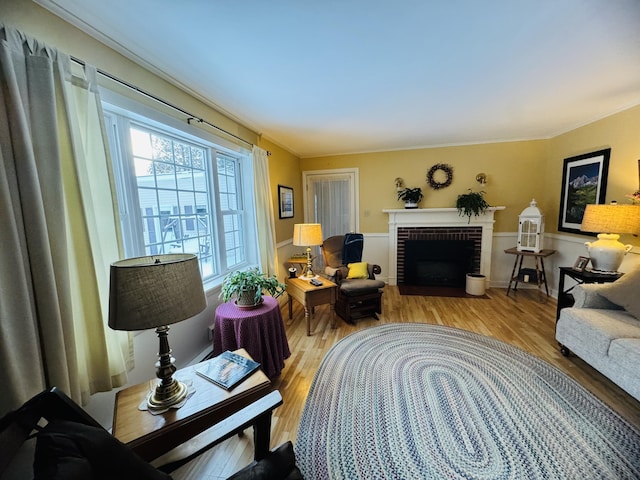 living room featuring light hardwood / wood-style flooring and a brick fireplace