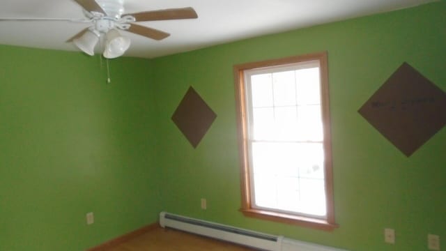 spare room with ceiling fan and a baseboard radiator