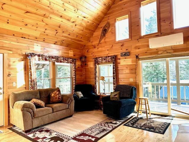 living room with high vaulted ceiling, wood ceiling, wood walls, and hardwood / wood-style flooring